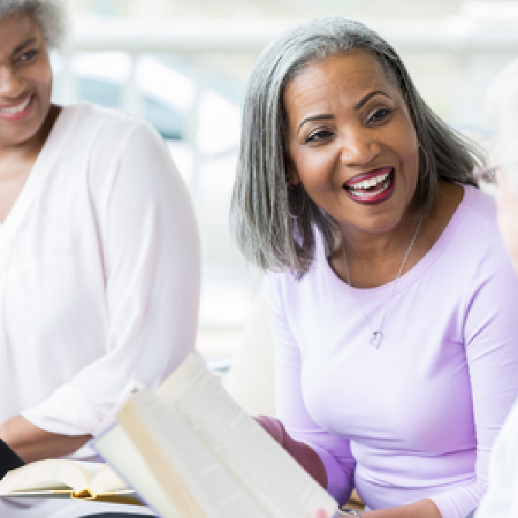 Three women reading and smiling