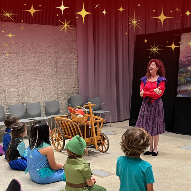 A woman telling a story to a crowd of children dressed in fantasy costumes.